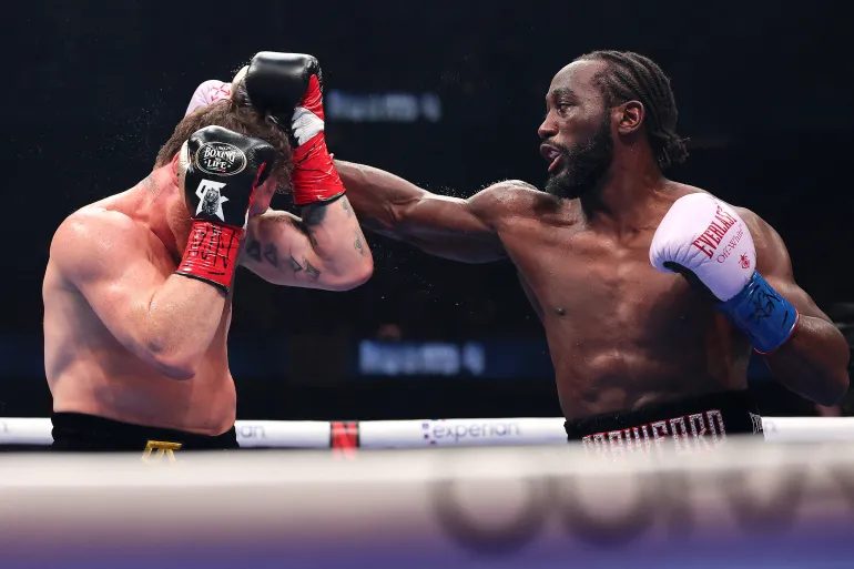 Terence Crawford raises his hands in victory after defeating Canelo Álvarez by unanimous decision to become the undisputed 168-lb champion in Las Vegas.